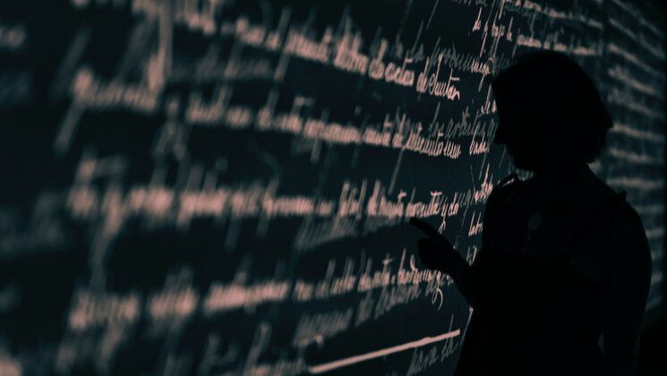 Blackboard with a text written on it and a person reading it